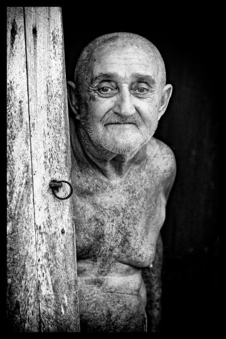 _E7A9478 Man with no shirt standing in doorway Trinidad B&W web ready